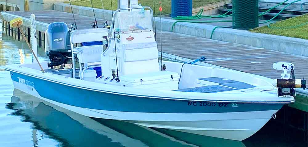 A boat is docked at the dock and ready to go.